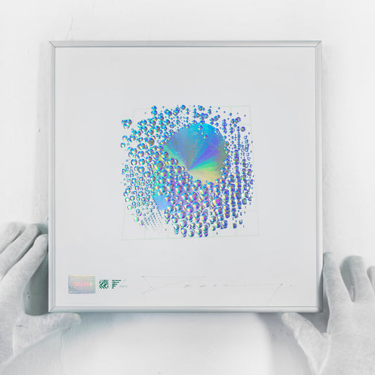 Demsky Vniversal:Energy, 2021 Lenticular print on Sappi paper, framed 11.81 x 11.81 in Edition of 150 Hand signed + numbered by the artist Attributions: Security Lenticular by H+M®? / Kurz – Germany Circular 4ºMultilevel Microembossing by H+M®? / Kurz – Germany Iriodine Optical Effect by Merk – Germany Bi-Chromic Optical Variable Security Ink by Petrel – France Holographic Foil by Univacco – Taiwan Sappi paper – South Africa