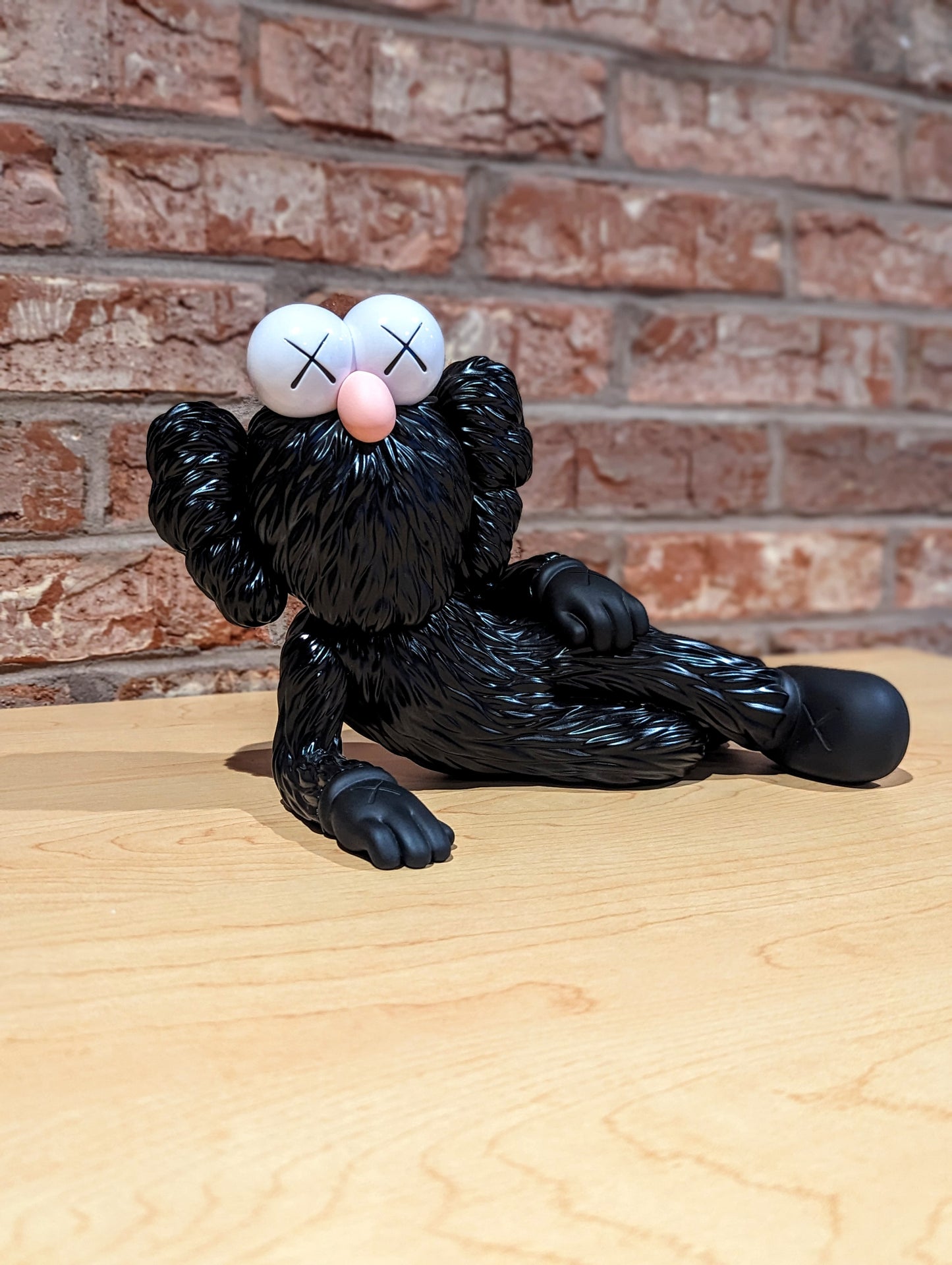 KAWS Time Off (Black), 2023 Vinyl figure 7.1 x 11 x 5.9 in KAWS is continuing his new standing tradition of Valentine's Day drops, with the release of his TIME OFF Vinyl Figures. The TIME OFF vinyl figure is lying down on his right side, with his legs crossed, and right hand supporting its head. The pink BFF figure has pink "X" marked eyes and "X" marked hands and feet, identical to KAWS’ Companion character. Each figure measures 7.1 x 11 x 5.9" and comes with a protective KAWS branded box.