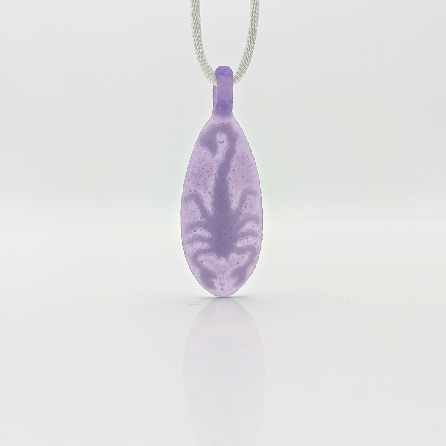 Kellie Thurston Scorpion (Purple Lollipop under Lotus White), 2024 Borosilicate Glass Pendant 66 mm x 26 mm Hand carved borosilicate glass pendant by Kellie Thurston. Prep by Dan Longden.