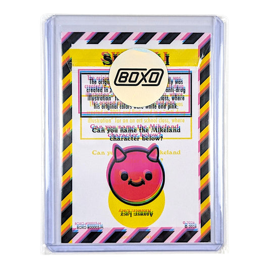 A collectible art card from the brand BOXO, featuring a pink devil character with black horns and a yellow circular background, surrounded by a clear protective sleeve with a black and pink striped border.