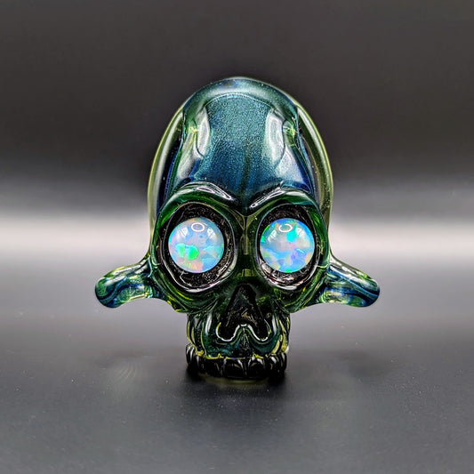 AKM  Skull, 2015 Illuminati Sleeved Borosilicate Glass Pendant with Opal Eyes Approx. 2.4 x 2.4 in  Hand blown glass made by AKM. Signed "AKM" + Dated "2015"