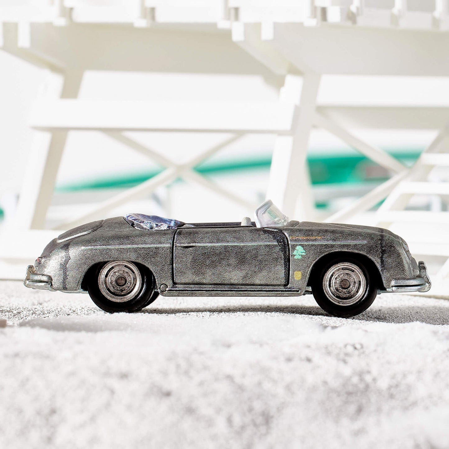 Daniel Arsham x Hot Wheels Porsche 356 “Bonsai” Speedster, 2023 Features: Sculpted crystallized erosions Body Color: Weathering effect to match ZAMAC color Body Type: ZAMAC Chassis: ZAMAC Wheels: Real Riders deep dish wheels with wash/wipe weathering effect Window Color: Clear Interior Color: Plastic replica of 1:1 version’s indigo-dyed Japanese textiles Scale 1:64 Includes sealing label and Certificate of Authenticity Packaged in a collector display case with simulated concrete base.