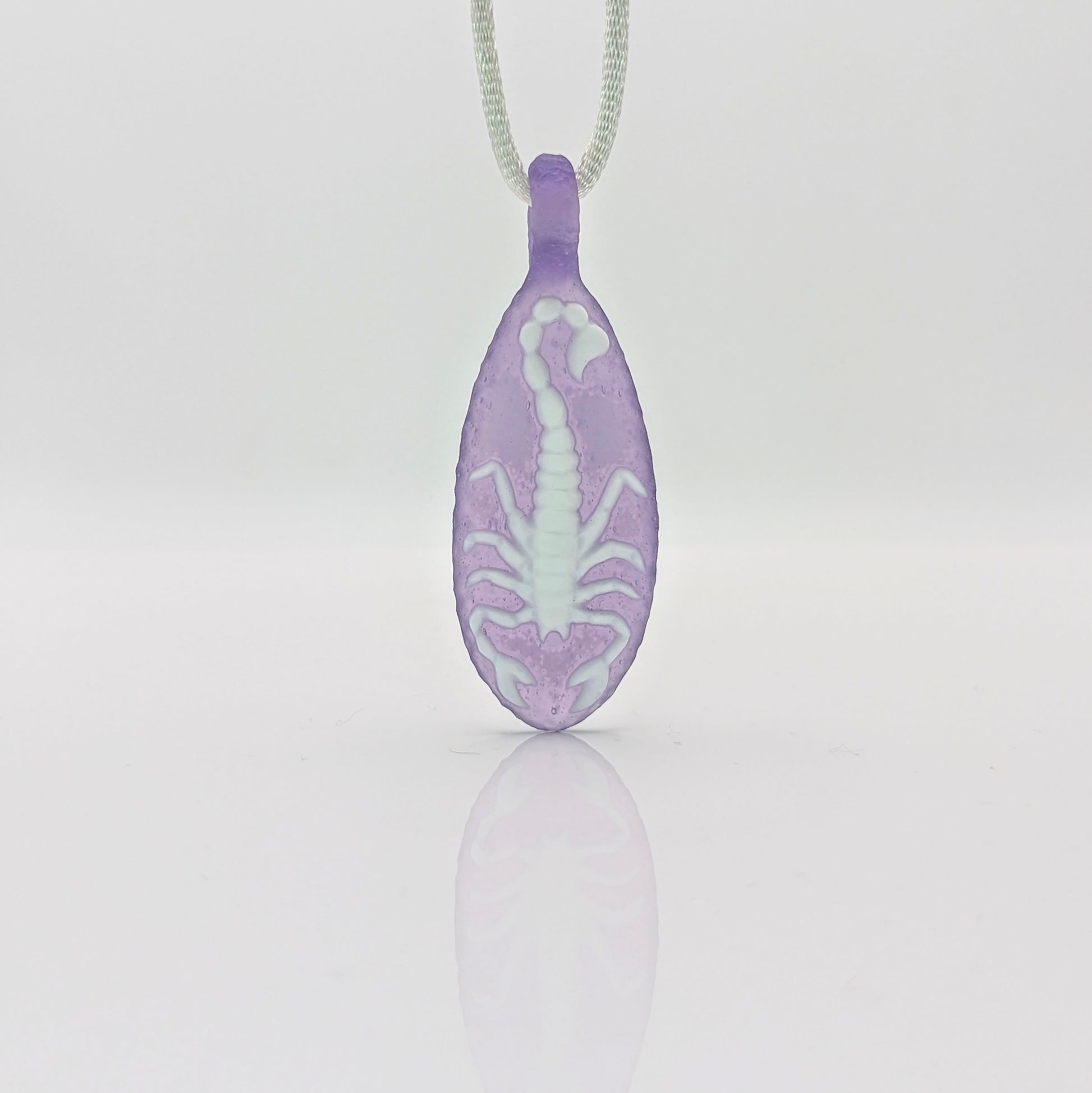 Kellie Thurston Scorpion (Purple Lollipop under Lotus White), 2024 Borosilicate Glass Pendant 66 mm x 26 mm  Hand carved borosilicate glass pendant by Kellie Thurston. Prep by Dan Longden. 
