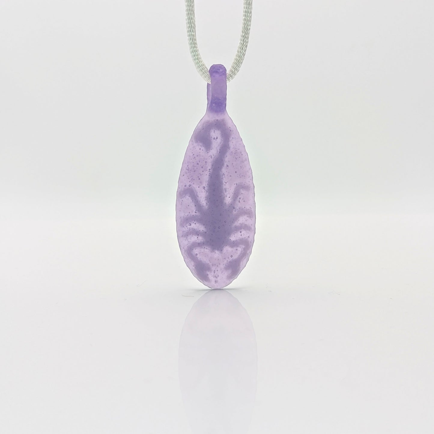 Kellie Thurston Scorpion (Purple Lollipop under Lotus White), 2024 Borosilicate Glass Pendant 66 mm x 26 mm  Hand carved borosilicate glass pendant by Kellie Thurston. Prep by Dan Longden. 