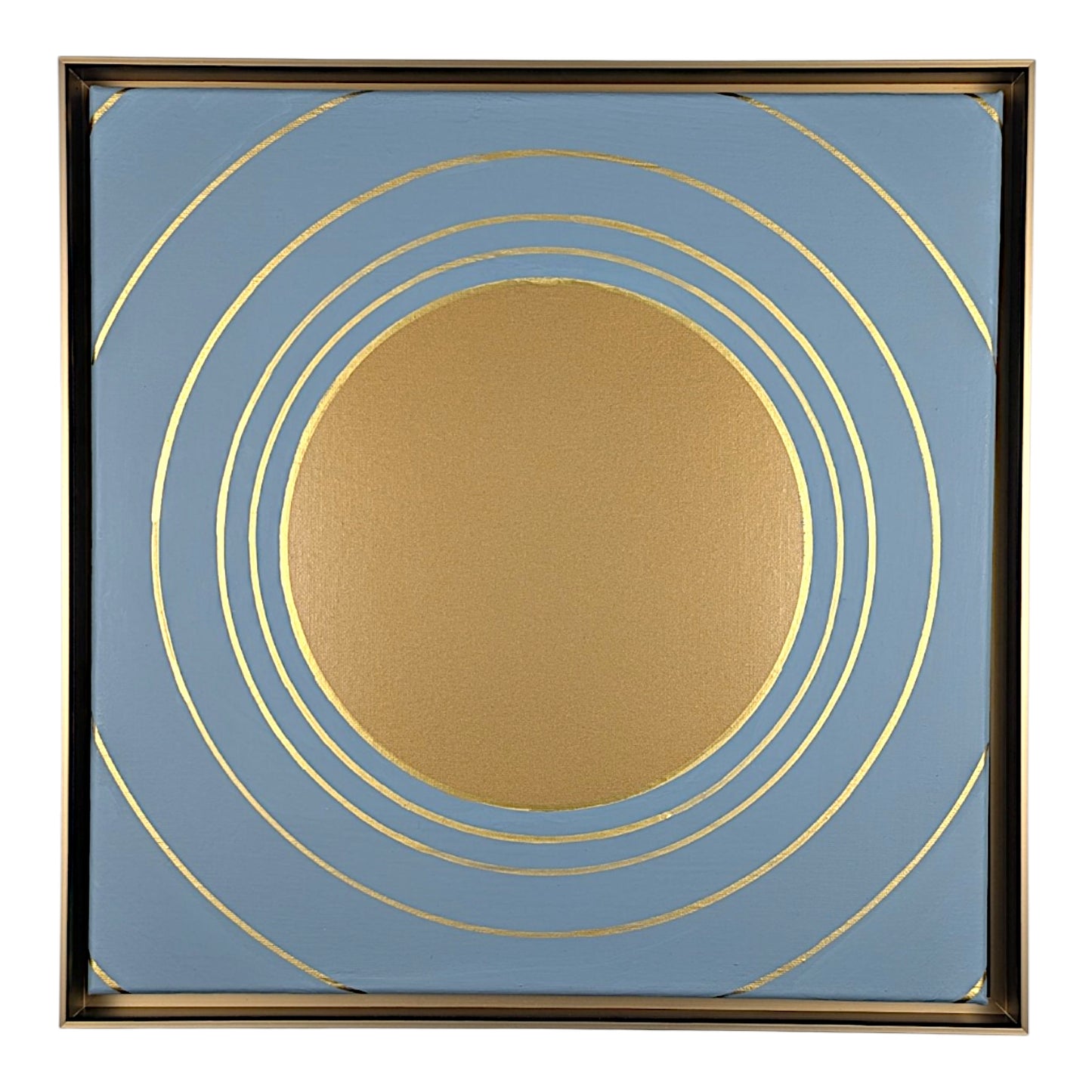 Square abstract wall art featuring a central gold circle surrounded by concentric gold rings on a dusty blue background, enclosed in a thin gold-toned frame.