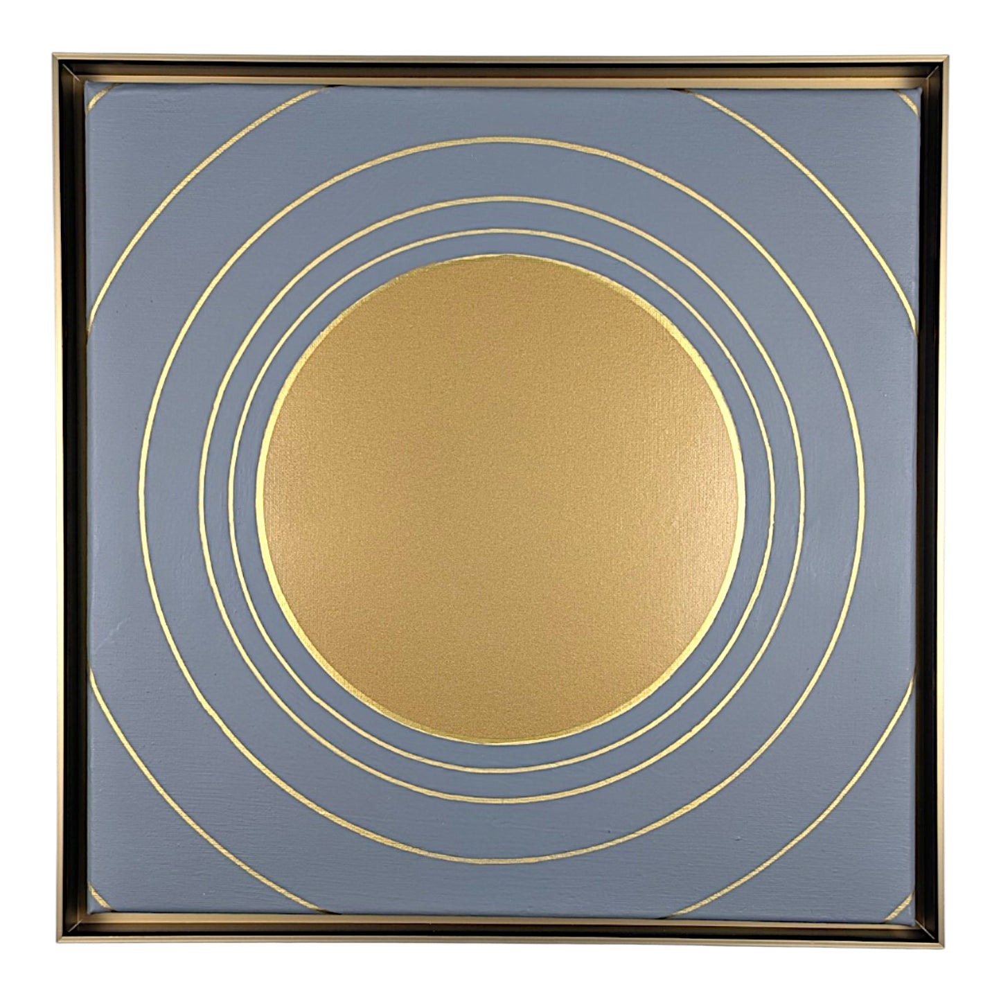 Square framed wall art featuring a minimalist gold sun and concentric rings design on a muted slate blue background, enclosed in a thin gold frame.
