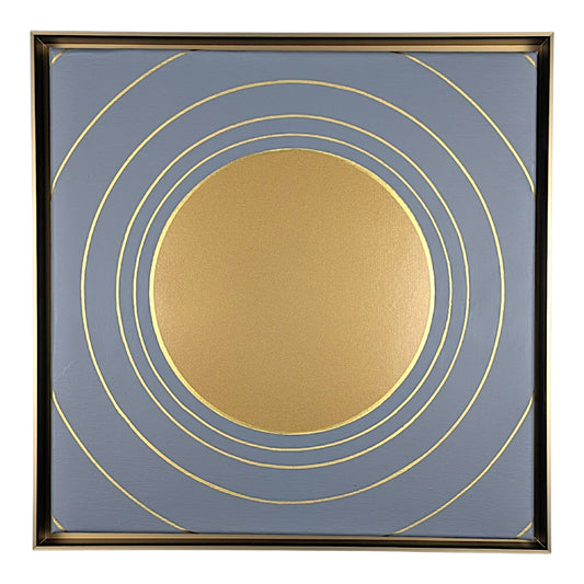 Square framed wall art featuring a minimalist gold sun and concentric rings design on a muted slate blue background, enclosed in a thin gold frame.