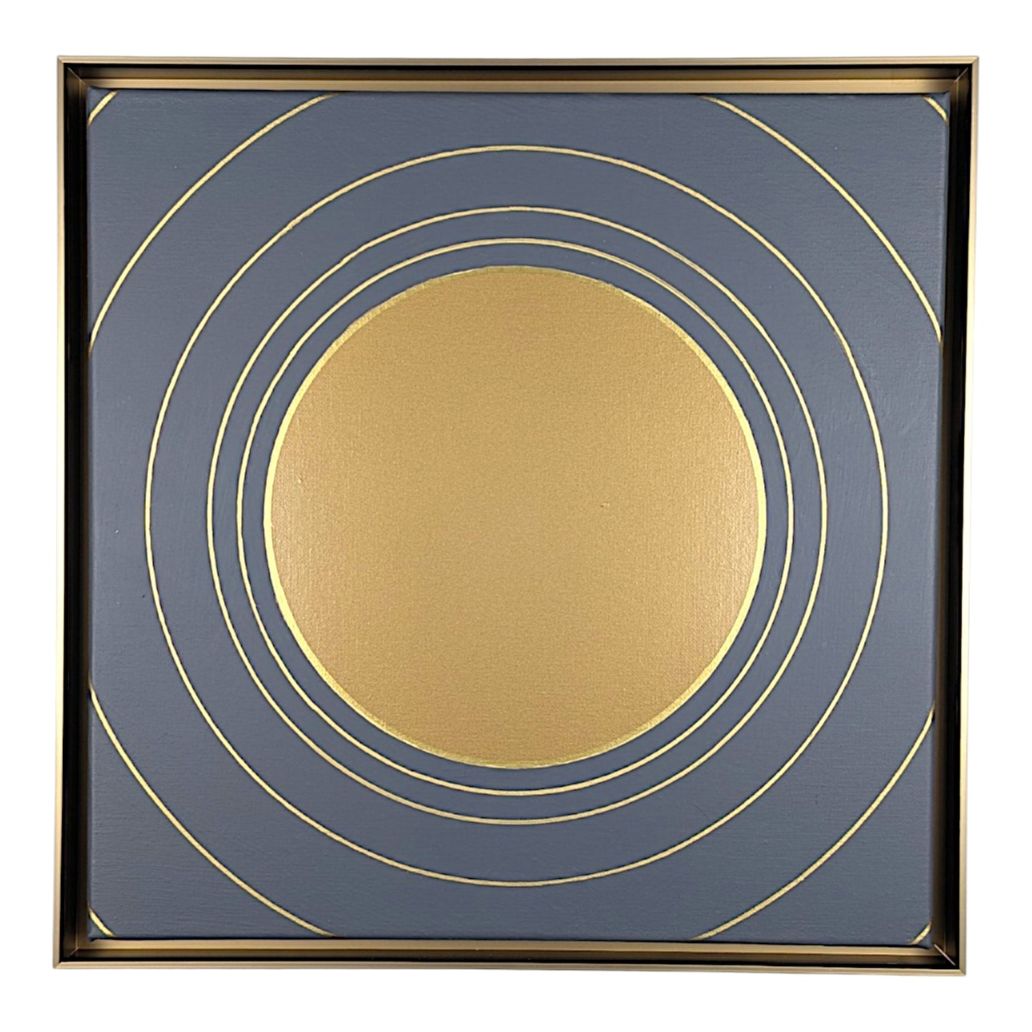 Square framed wall art featuring a minimalist gold circular design on a slate blue background, enclosed in a thin gold frame.