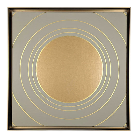 Square decorative wall art featuring a metallic gold circular motif surrounded by concentric gold rings on a light gray background, enclosed in a thin gold-toned frame.