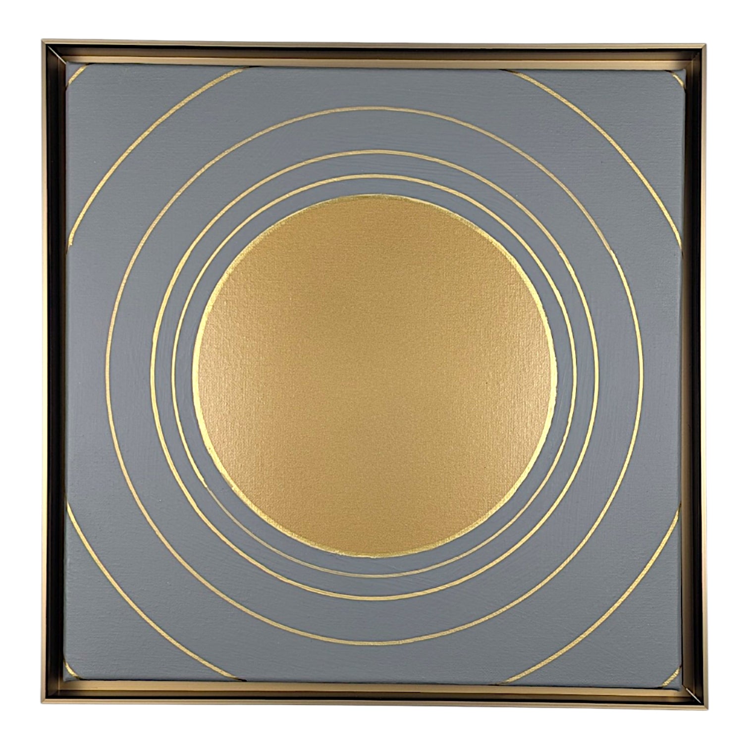 Square framed wall art featuring a metallic gold sun-like circle centered on a slate gray background with concentric gold rings and a thin gold frame.