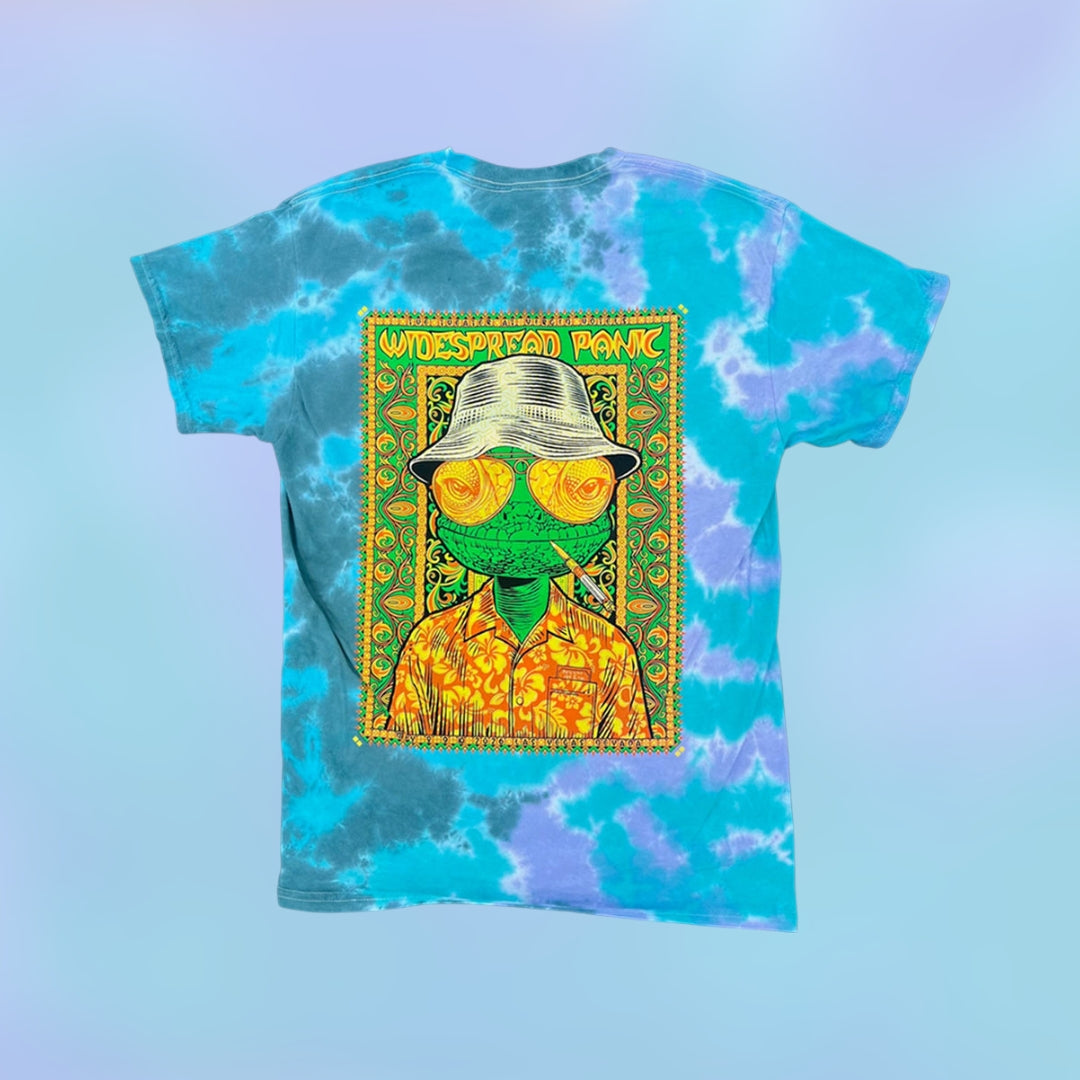 Todd Slater Widespread Panic Vegas 2026 "Fear & Loathing" Tie Dye Shirt 

- Printed on a Colortone T Shirt by Ruby Sue Graphics 
- 100% cotton 
- Pre-shrunk 
- Classic fit 
- Ribbed collar 
- Shoulder-to-shoulder taping 
- Double-needle sleeves and bottom hem 
- Sewn in label 

*Please note there may be slight variations in color and fit (up to 1–2 inches) due to the custom dye process. Wash separately and enjoy the uniqueness of your garment!