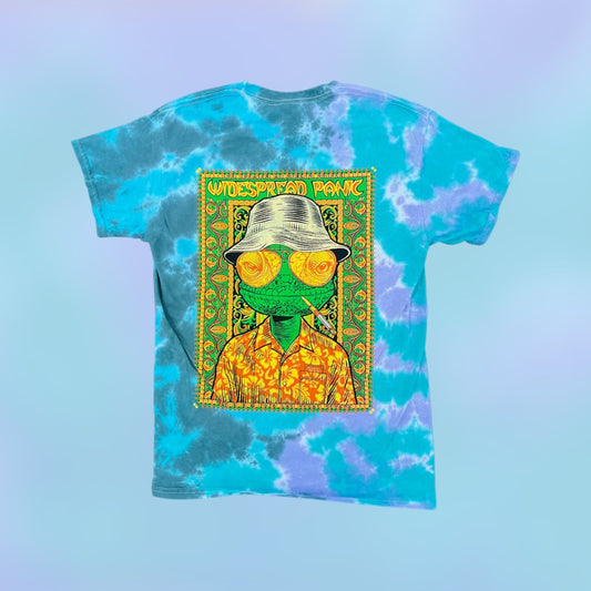 Todd Slater Widespread Panic Vegas 2026 "Fear & Loathing" Tie Dye Shirt 

- Printed on a Colortone T Shirt by Ruby Sue Graphics 
- 100% cotton 
- Pre-shrunk 
- Classic fit 
- Ribbed collar 
- Shoulder-to-shoulder taping 
- Double-needle sleeves and bottom hem 
- Sewn in label 

*Please note there may be slight variations in color and fit (up to 1–2 inches) due to the custom dye process. Wash separately and enjoy the uniqueness of your garment!